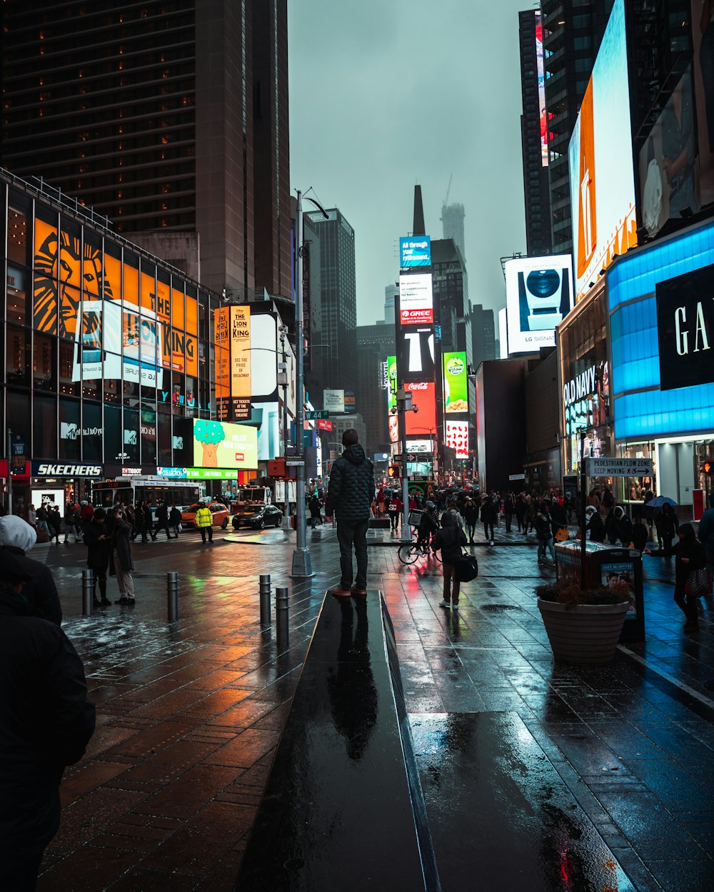 people walking between buildings with electronic billboards