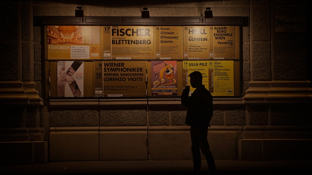 silhouette of man beside posters