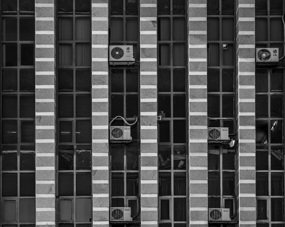 edifício cinza e preto com unidade condensadora AC durante o dia