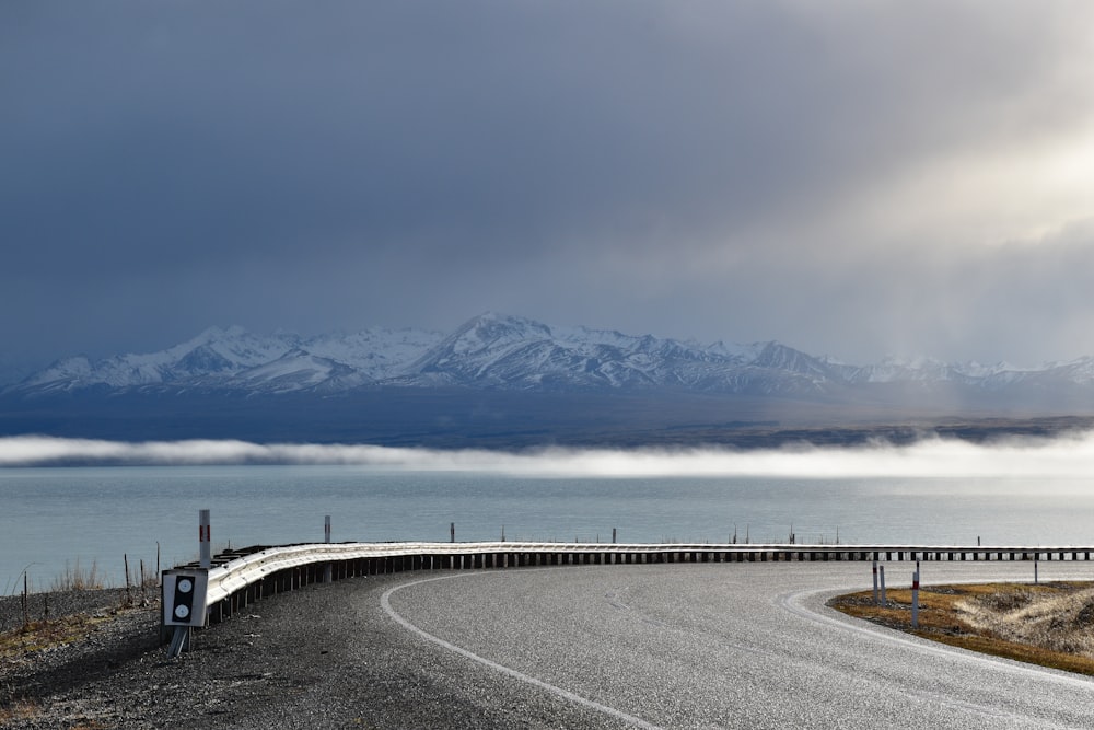 a winding road with a mountain range in the background