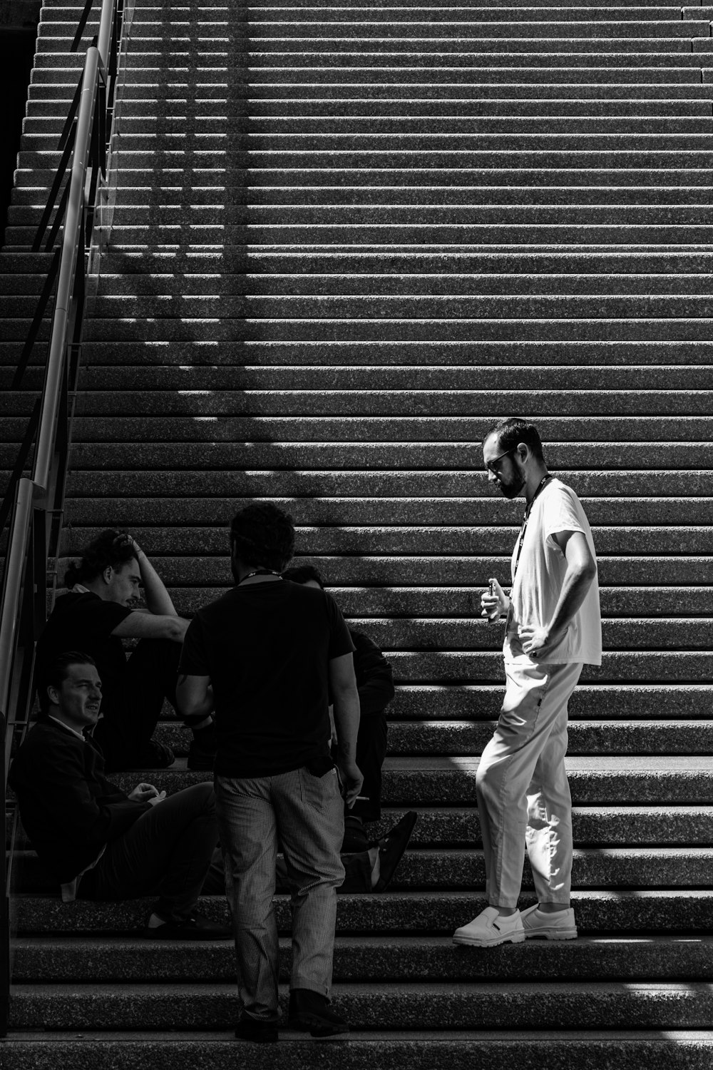 grayscale photo of man standing on stairs