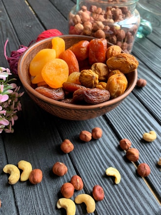 A variety of nuts and dried fruits displayed in wooden bowls.
