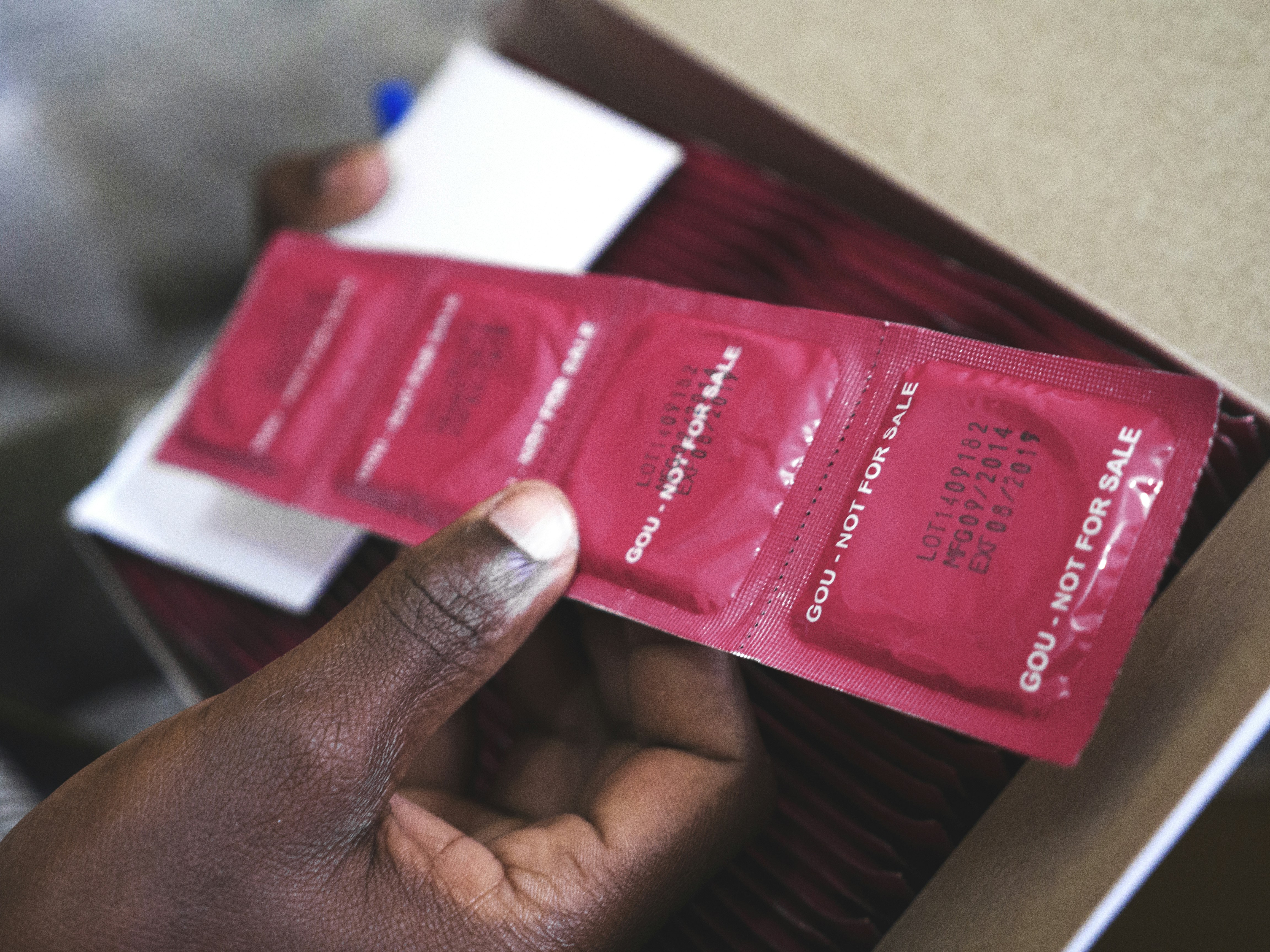 Man holding a blister of condoms