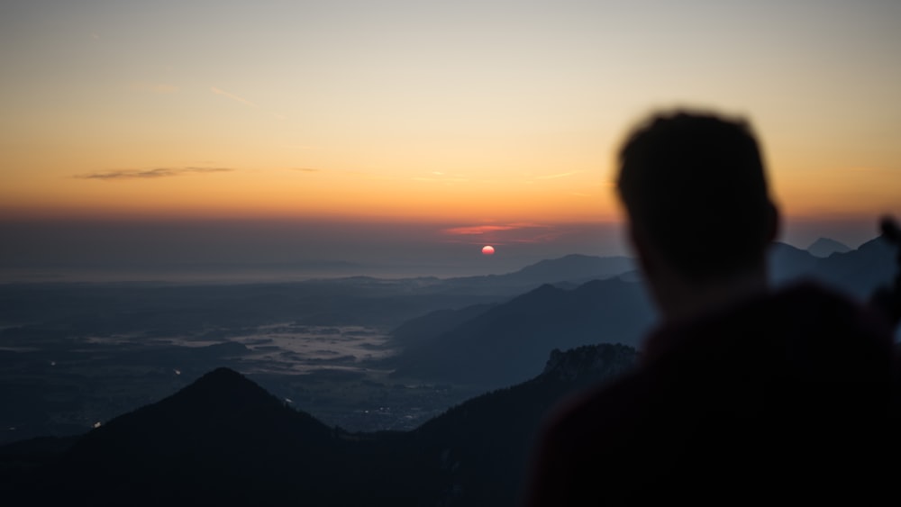 man facing mountain ranges