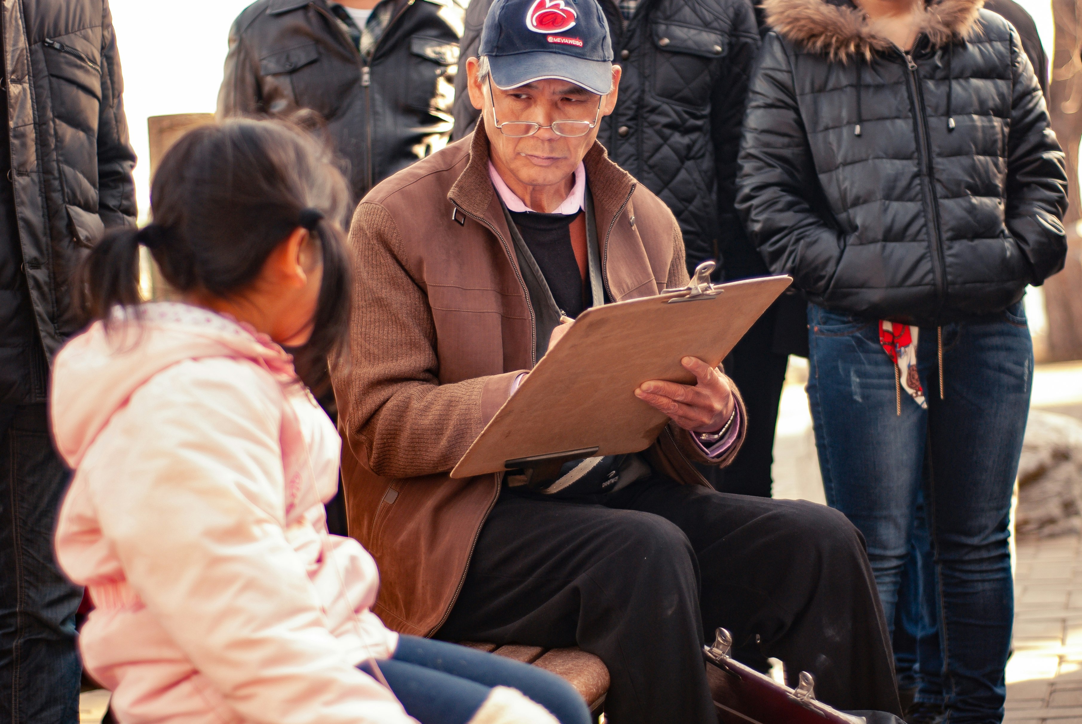 man sitting beside sitting girl in pink hoodie