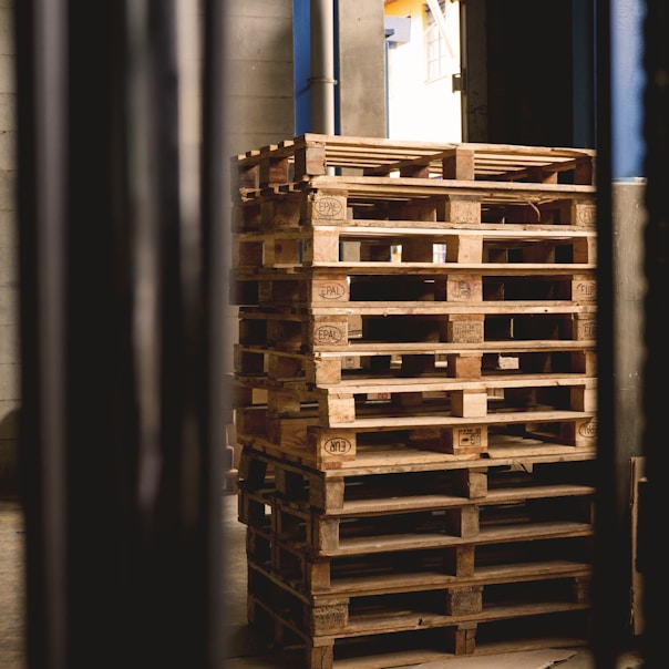 selective focus photography of piled brown wooden pallets