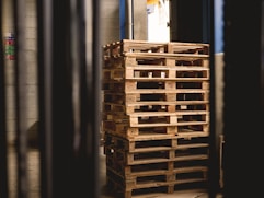 selective focus photography of piled brown wooden pallets