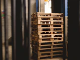 selective focus photography of piled brown wooden pallets