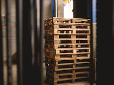selective focus photography of piled brown wooden pallets