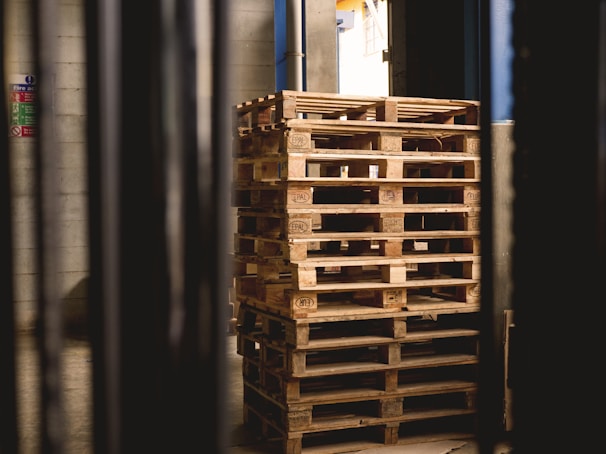 selective focus photography of piled brown wooden pallets