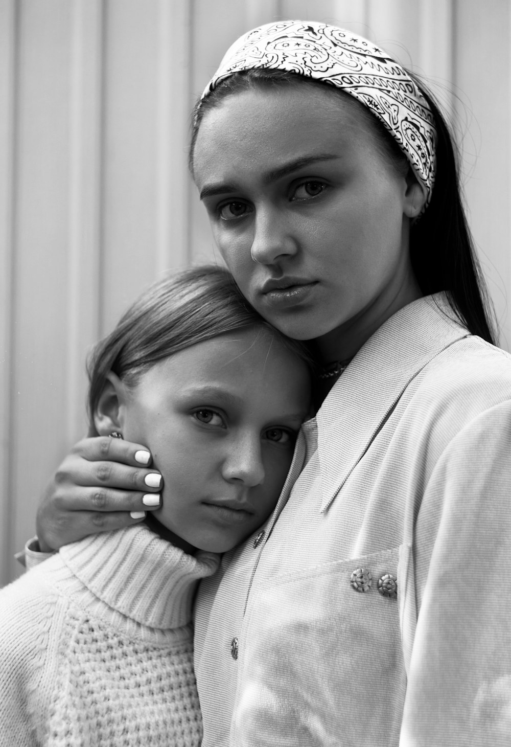 grayscale photo of woman hugging girl