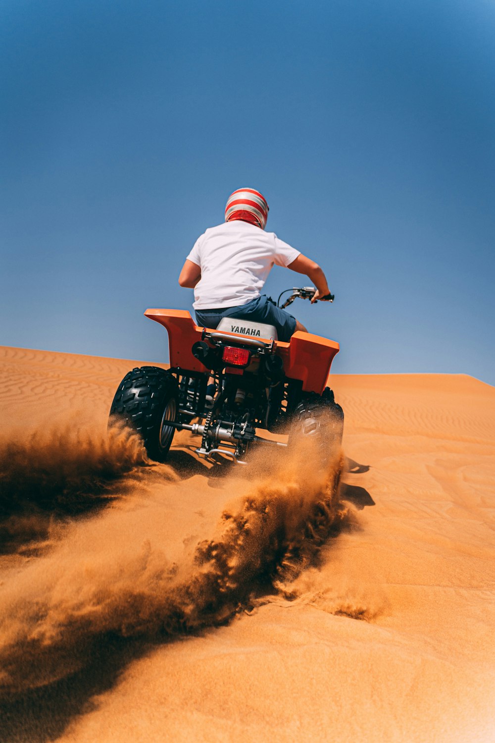 person riding ATV on desert during daytime