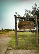 A rustic wooden sign reading 'Kristin Rides Scholarship' surrounded by wildflowers.