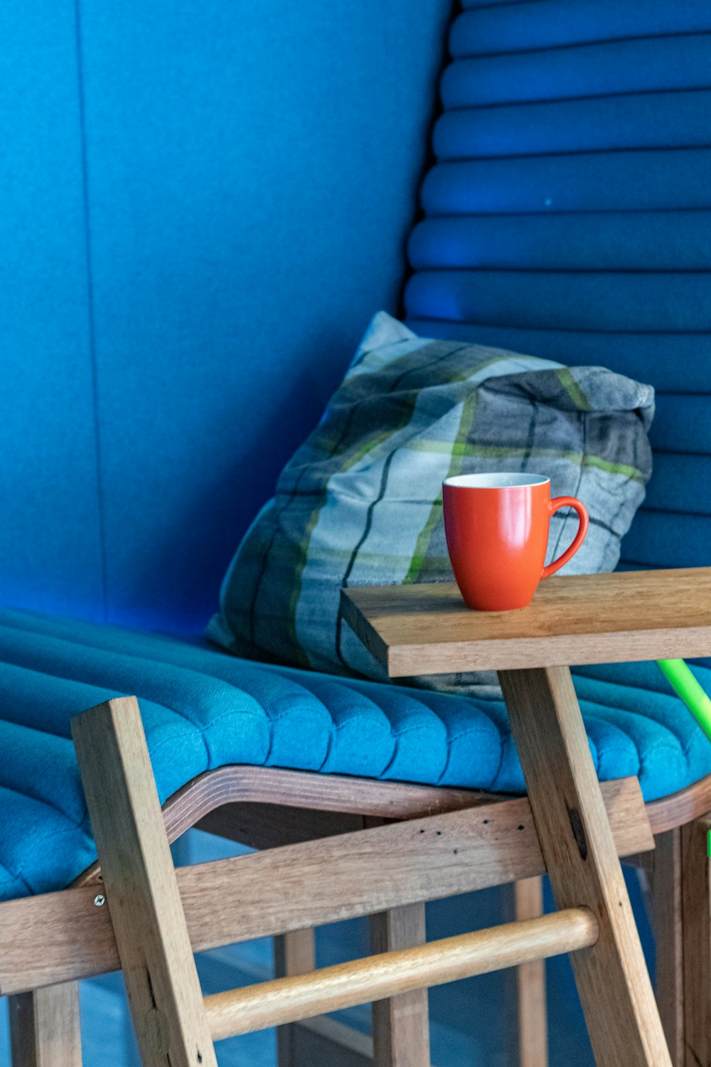 red ceramic mug on brown wooden armchair