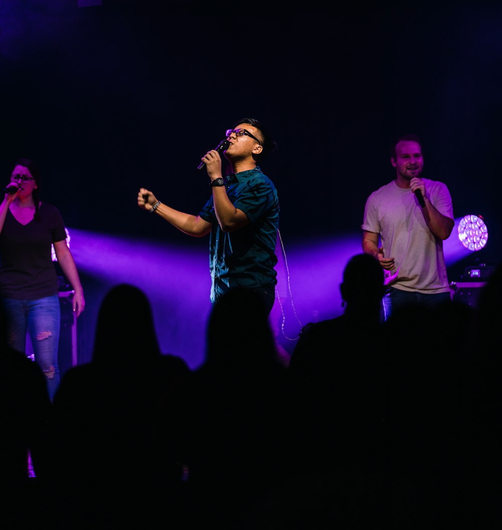 selective focus photography of three people performing on stage