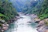 A joyful family navigating gentle rapids surrounded by lush green forest in Ubud.