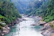 A joyful family navigating gentle rapids surrounded by lush green forest in Ubud.