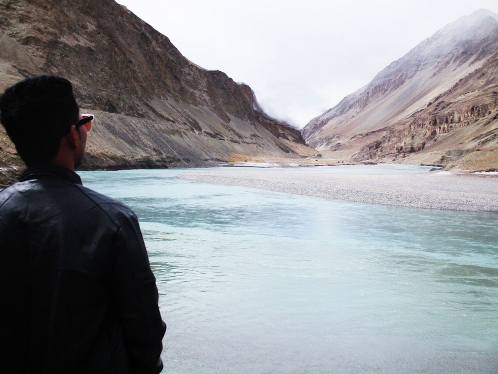 person standing in front of body of water during daytime