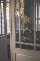 A sunlit window with children's drawings taped to the glass, symbolizing hope and family warmth.
