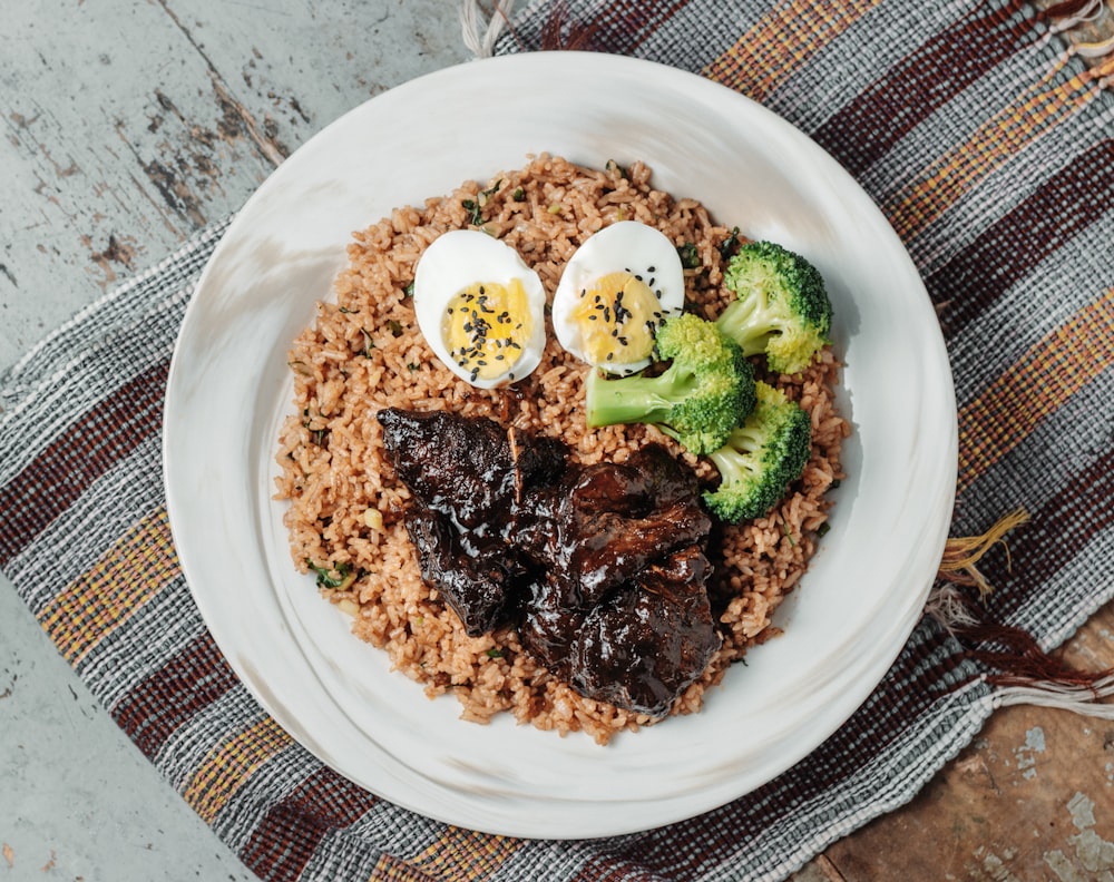 shallow focus photo of boiled egg and broccoli on brown rice