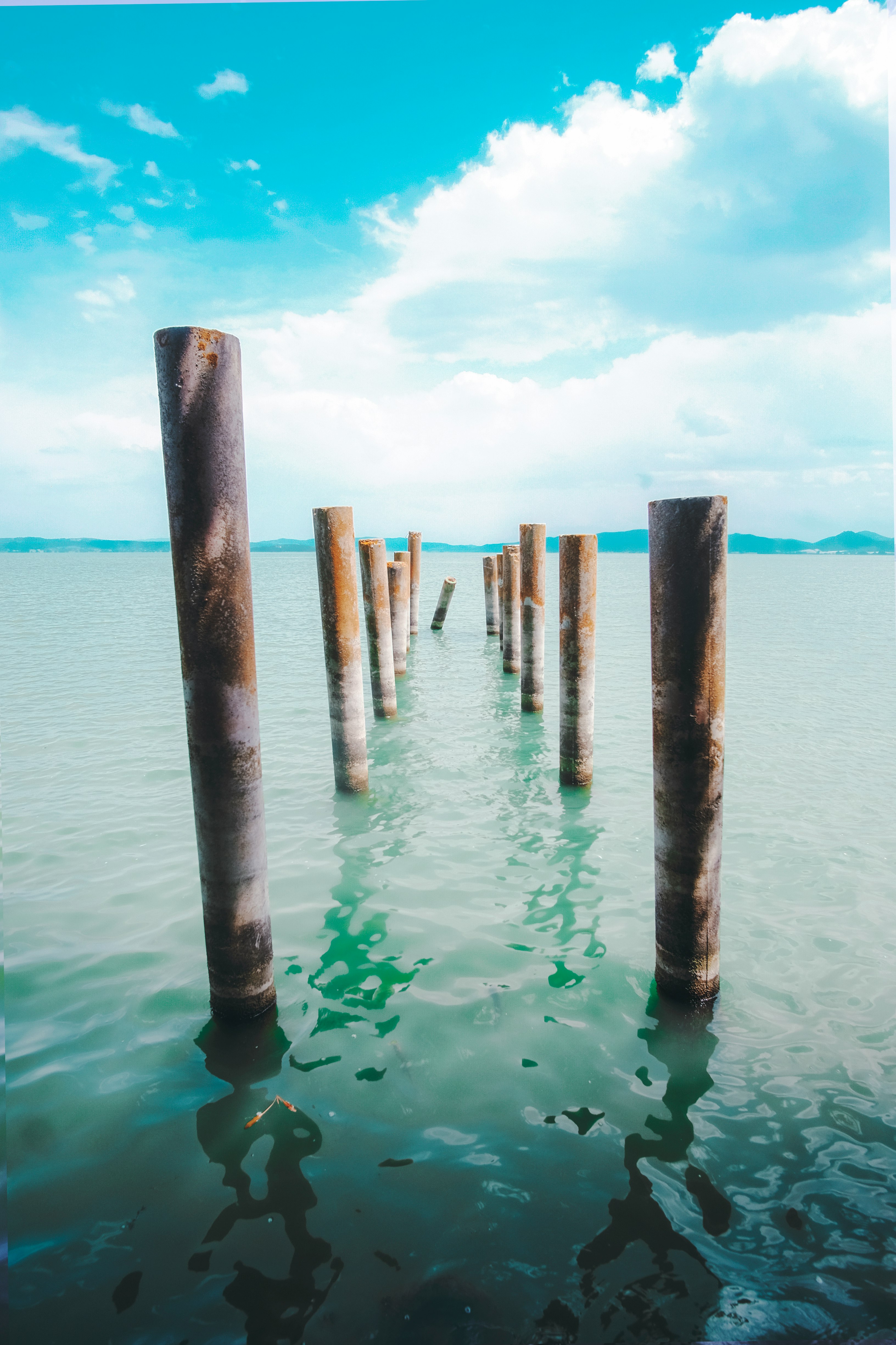 brown wooden poles on body of water during daytime