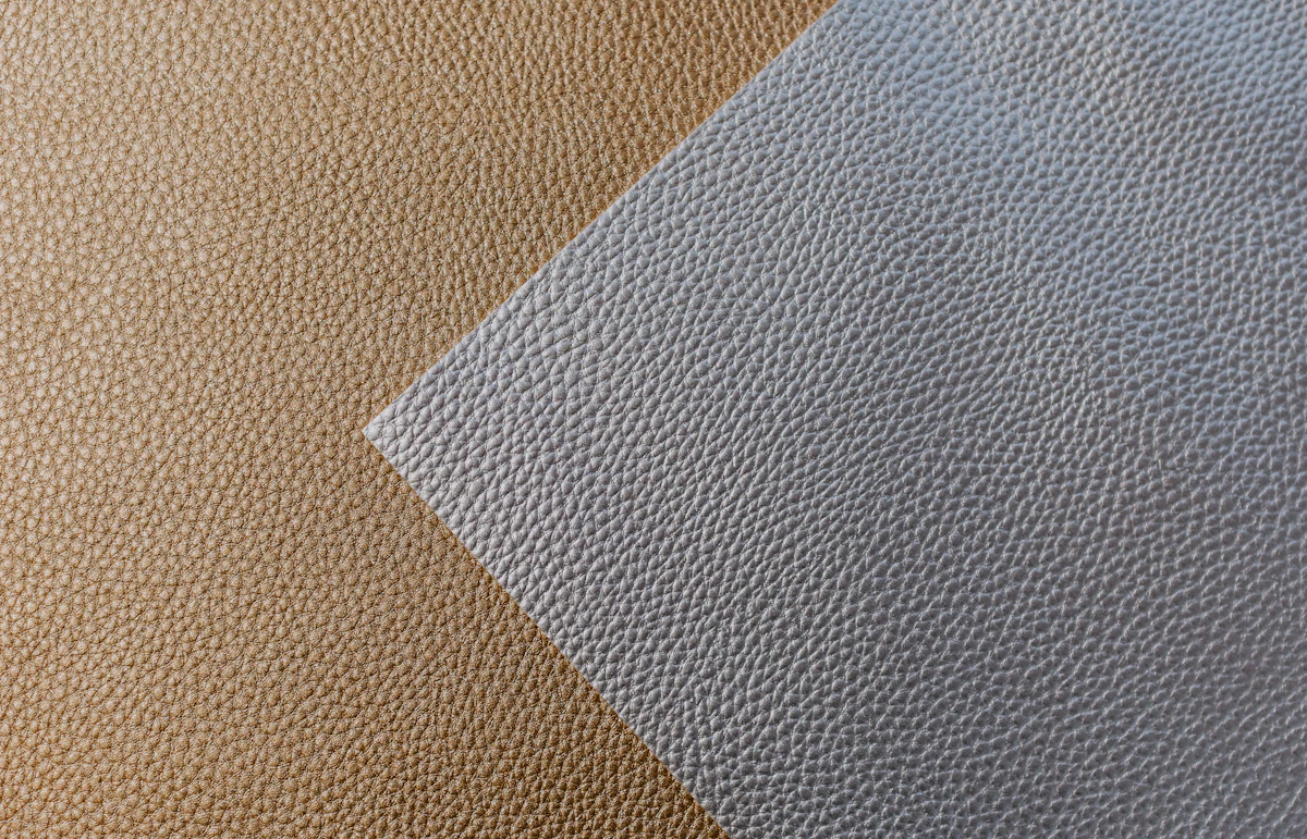 Two leather samples, tan and grey, side by side