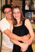 A happy couple holding their 3D printed wedding figurines, smiling at the camera.