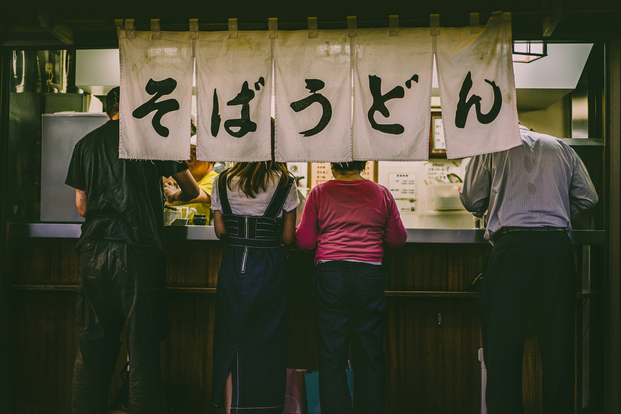 People eating standing up at ramen restaurant in Tokyo, Japan