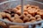 A close-up view of a tray filled with various types of fried or baked snacks, including rolls with sausage filling, brown round croquettes, and other golden-brown finger foods.