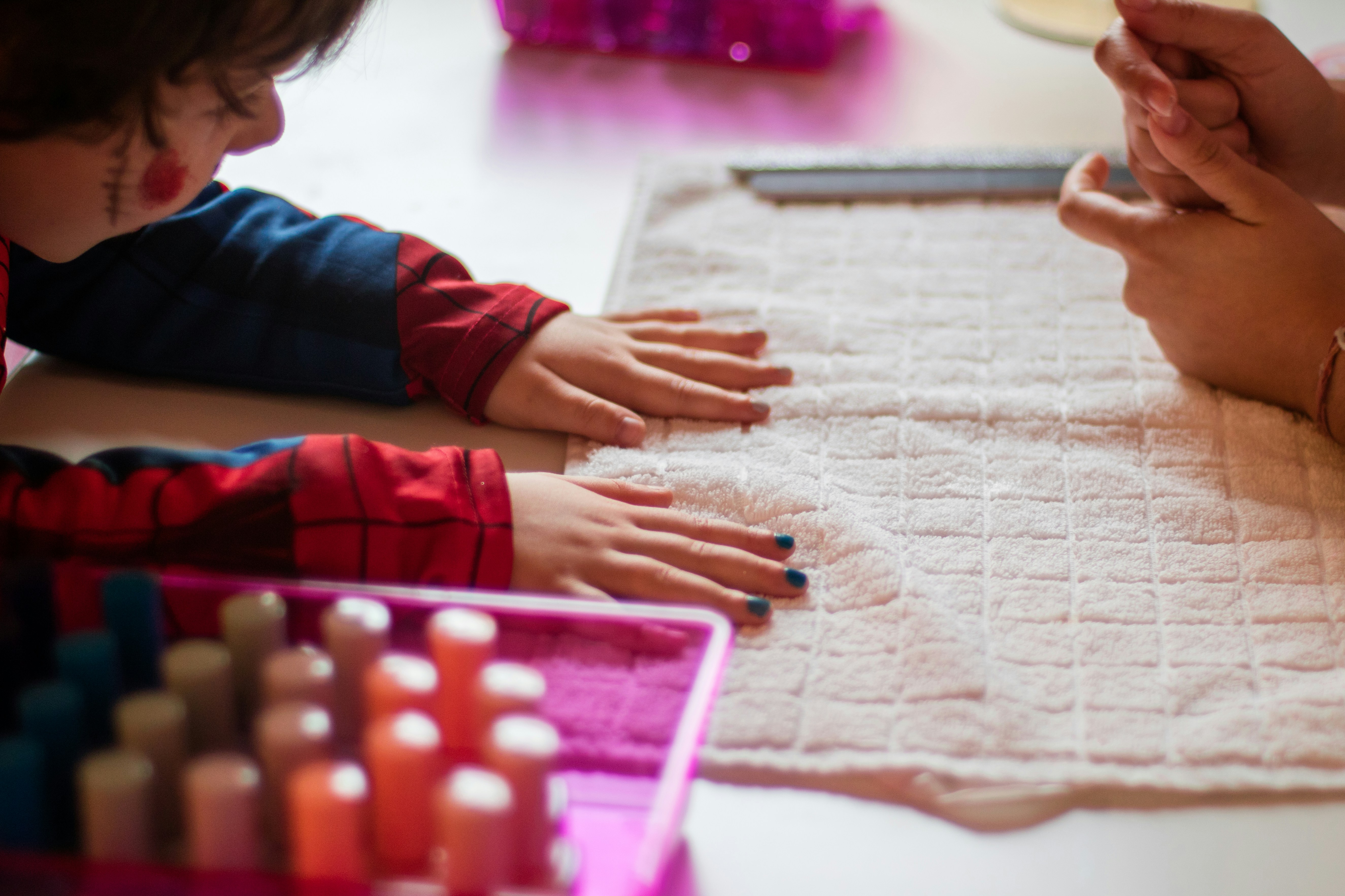 child touching white towel near person