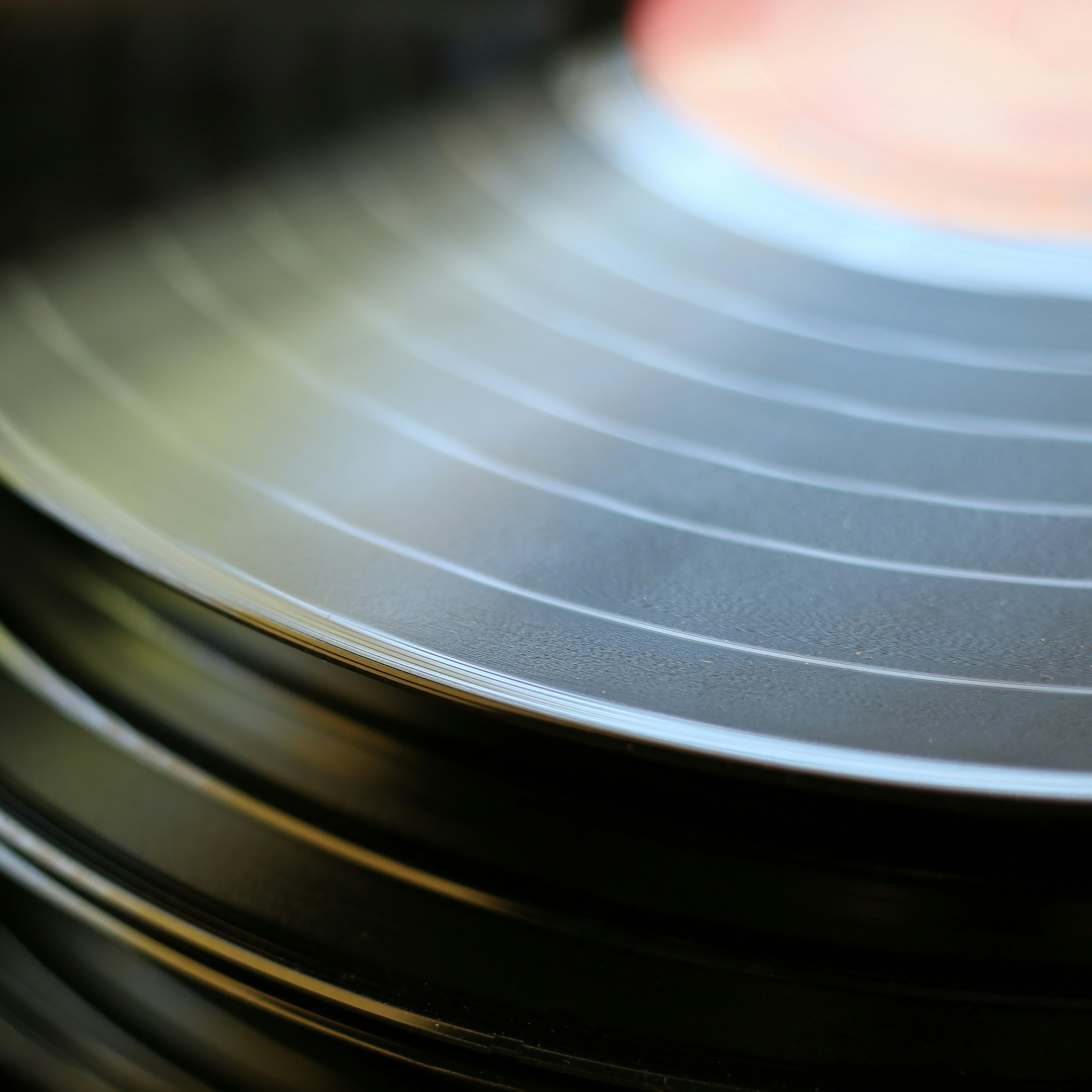 A close-up of hands on a vinyl turntable.