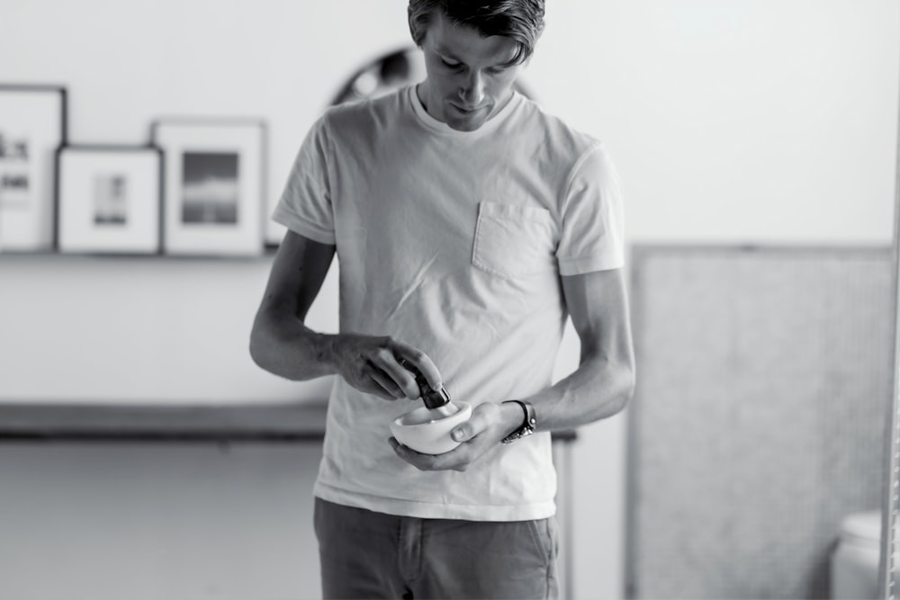 grayscale photo of man in white crew-neck pocket T-shirt