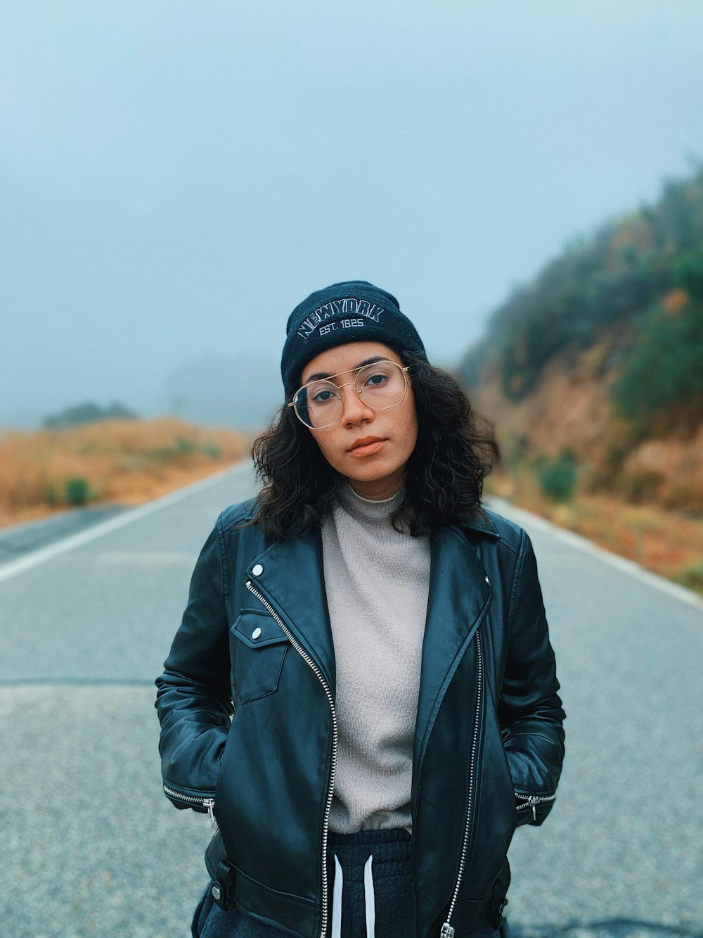 woman wearing black leather zip-up jacket and knit cap