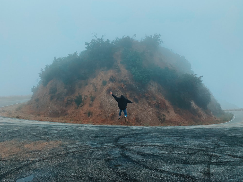 man jumping on asphalt road