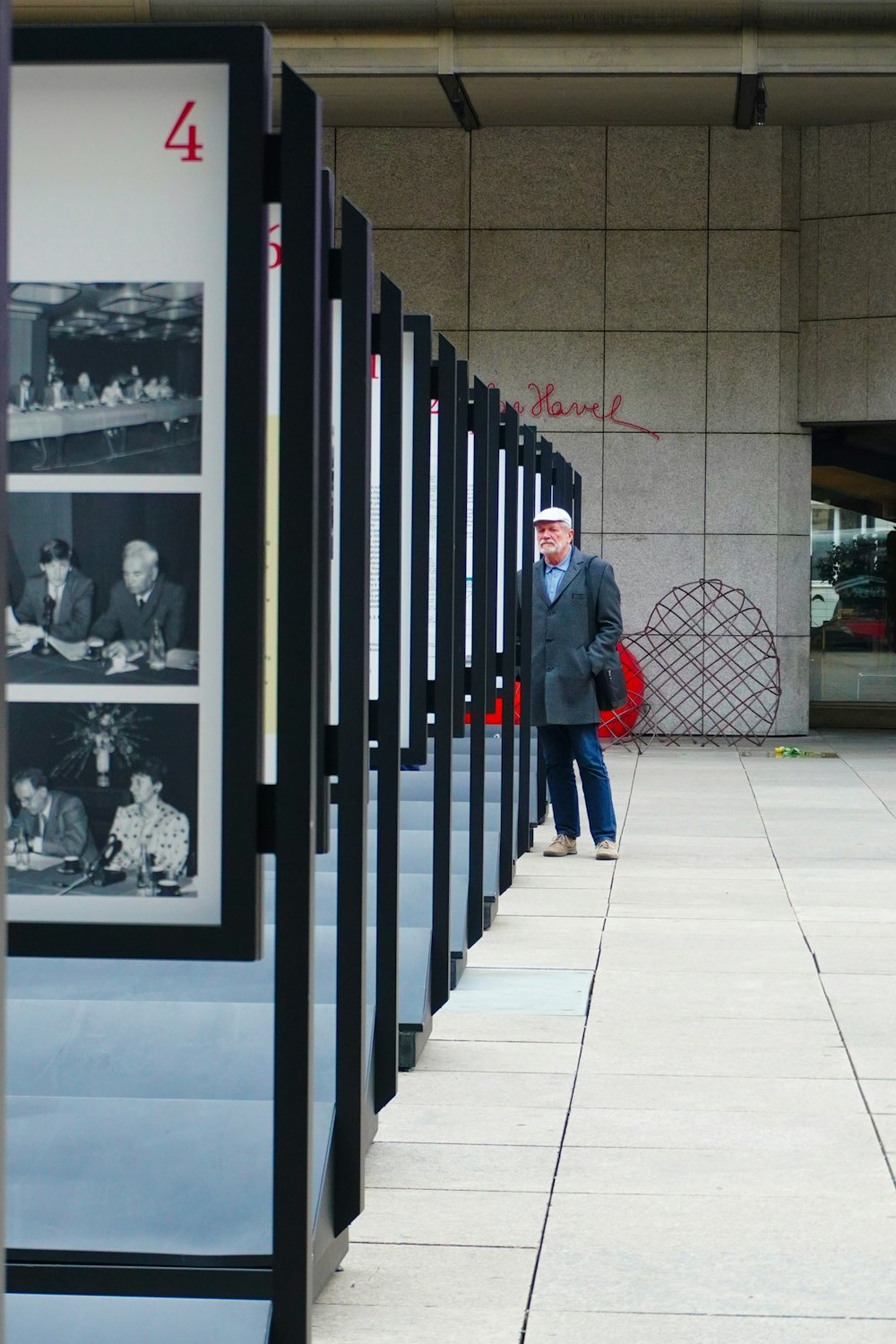 man standing in front of lined of portraits