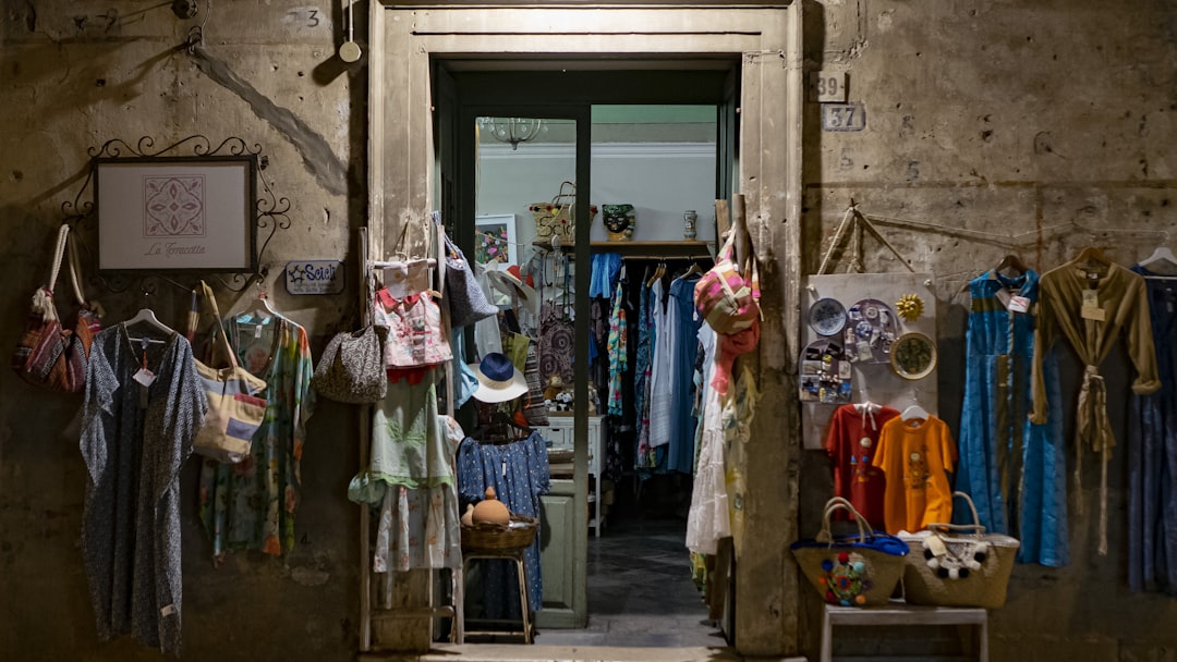 assorted clothes hanging in front of store, Scicli, a little local dress shop.<p></figure>