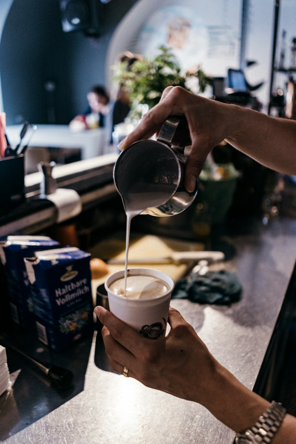 person pouring in white plastic cup