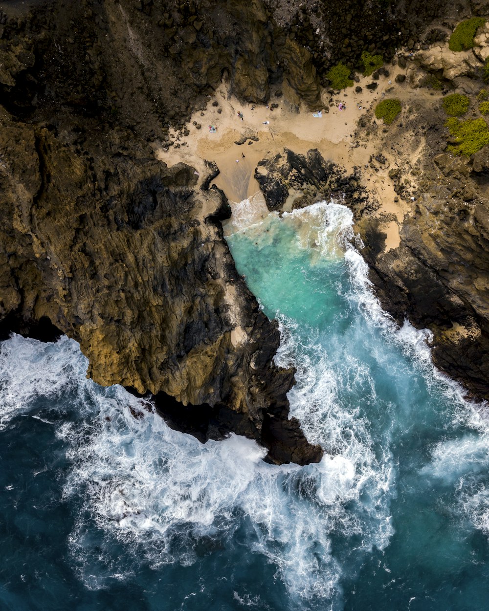 Fotografía aérea de un acantilado viendo un cuerpo de agua durante el día