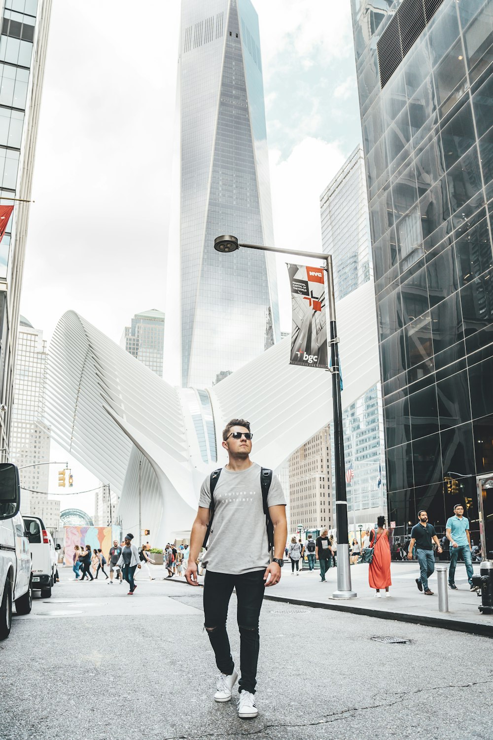 people standing near city with high-rise buildings under white and blue sky during daytime