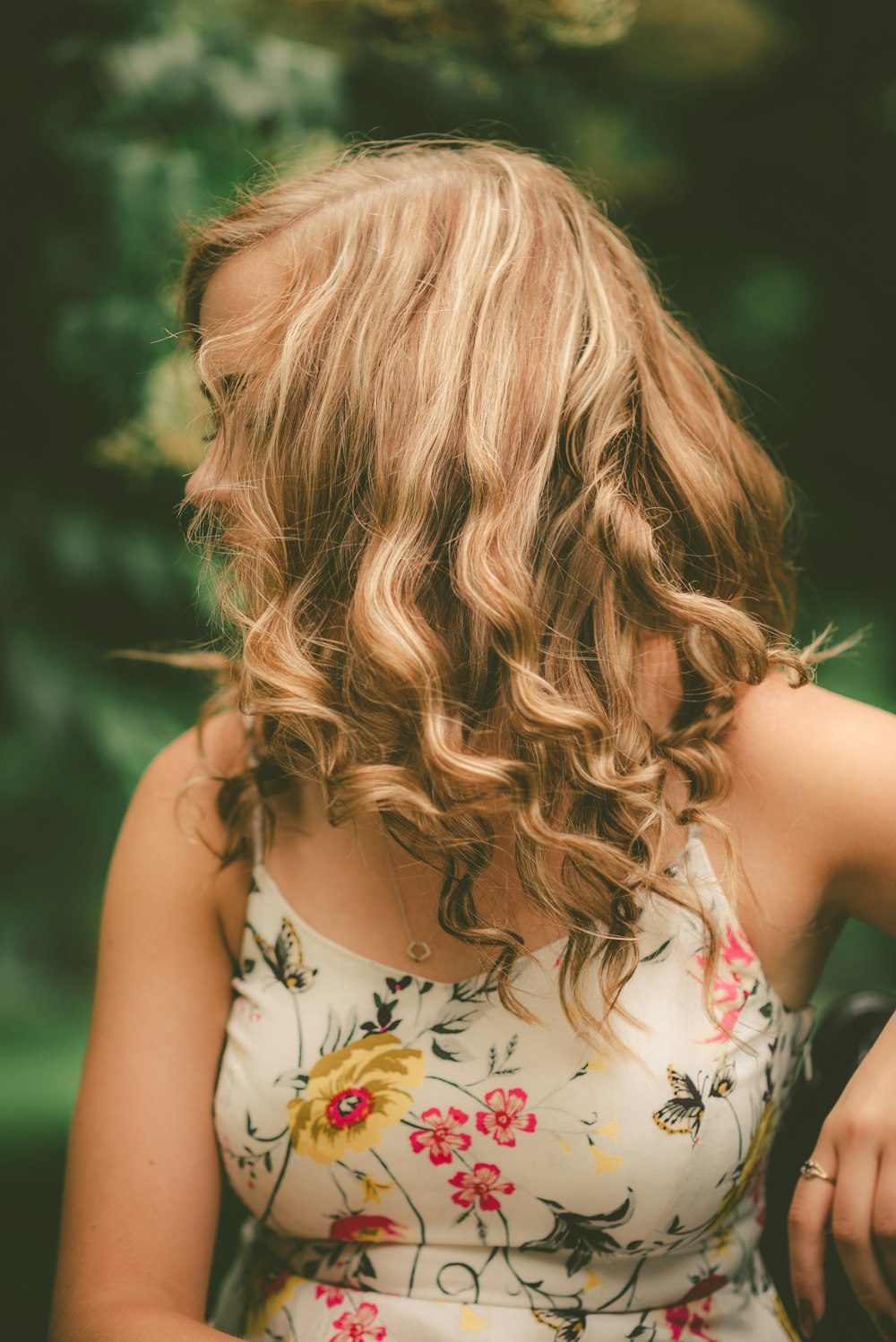 woman wearing white and multicolored floral spaghetti strap dress facing her right side