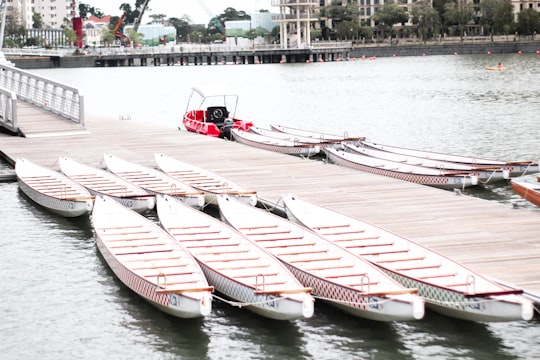 white canoes near wooden dock during daytime in Kallang Singapore