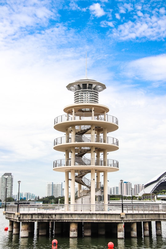 white tower building near body of water under white and blue sky during daytime in Kallang Singapore