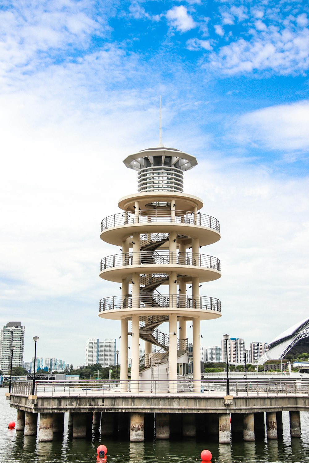 white tower building near body of water under white and blue sky during daytime