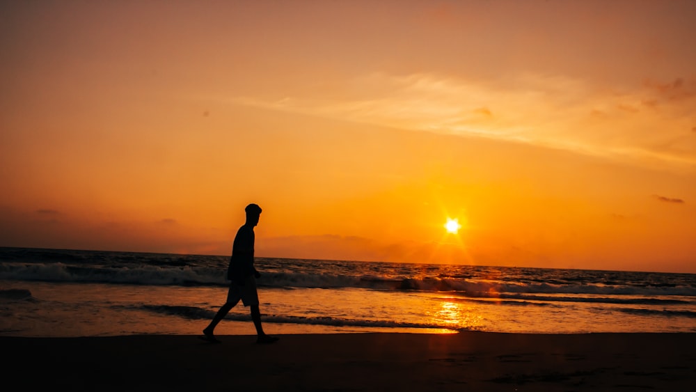 silhouette of person standing on seashore