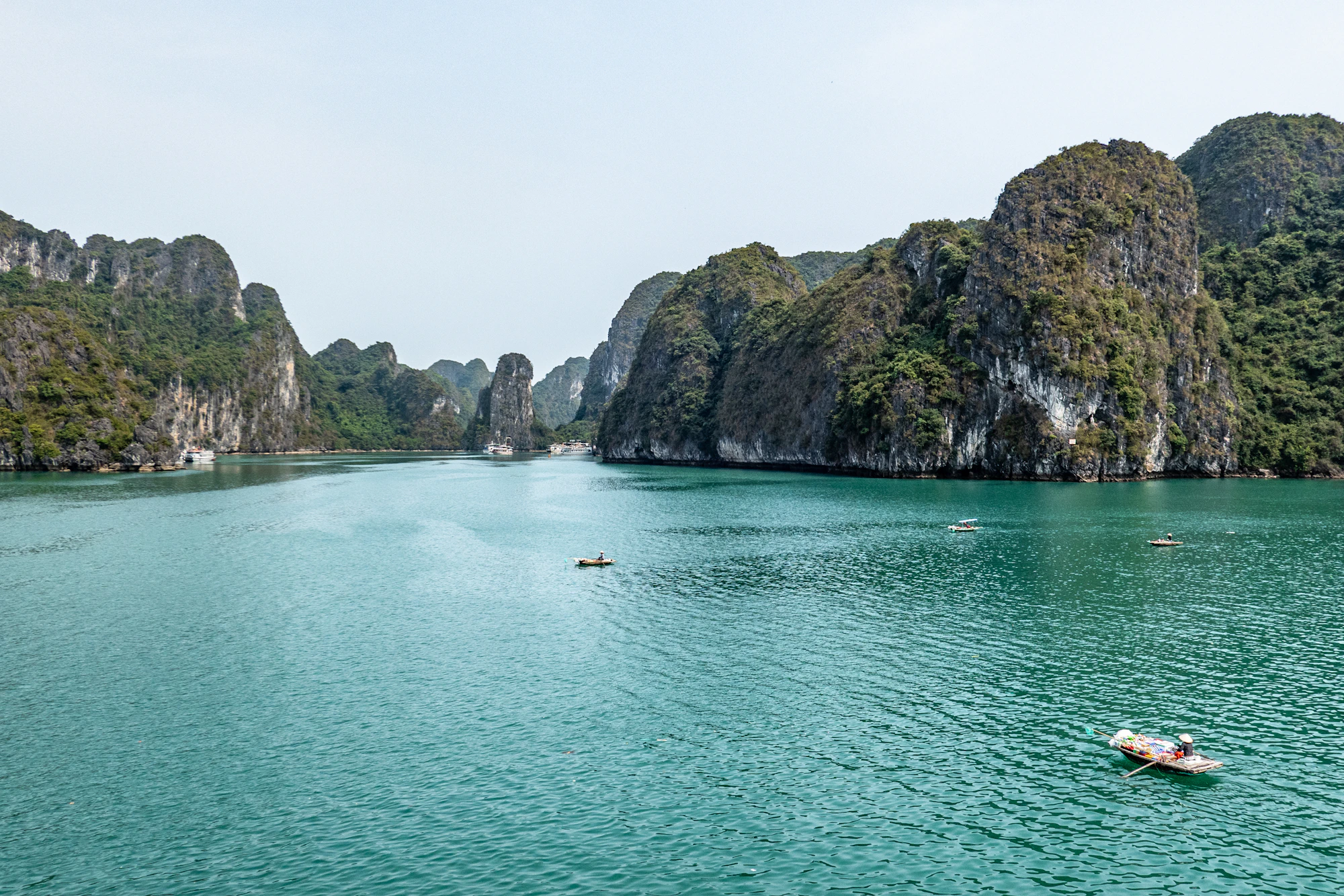 A junk cruise drifting through Ha Long Bay at golden hour