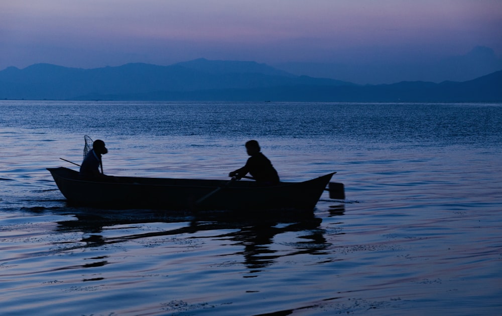 person and dog in boat during dawn