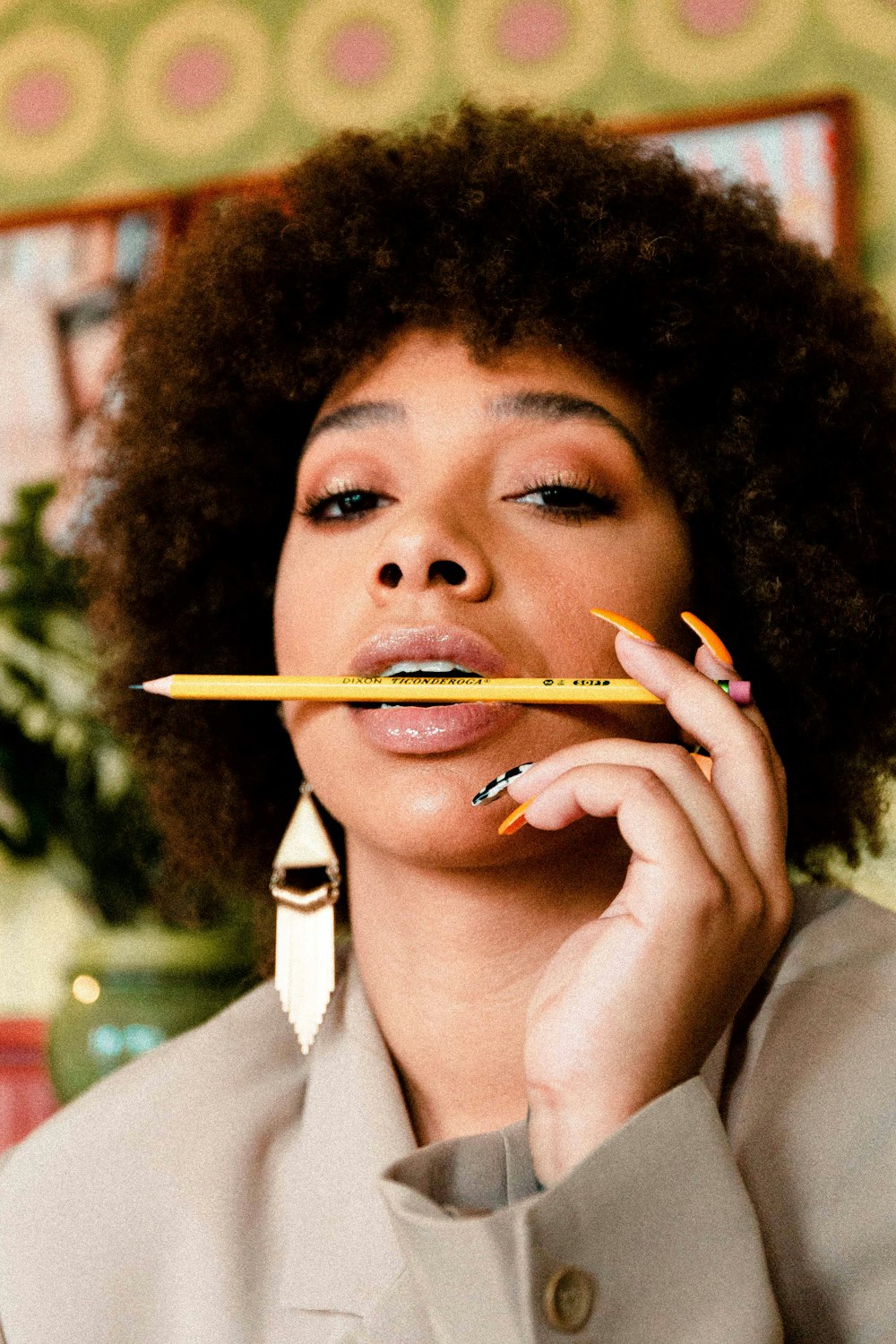 woman wearing brown coat putting yellow wooden pencil on mouth