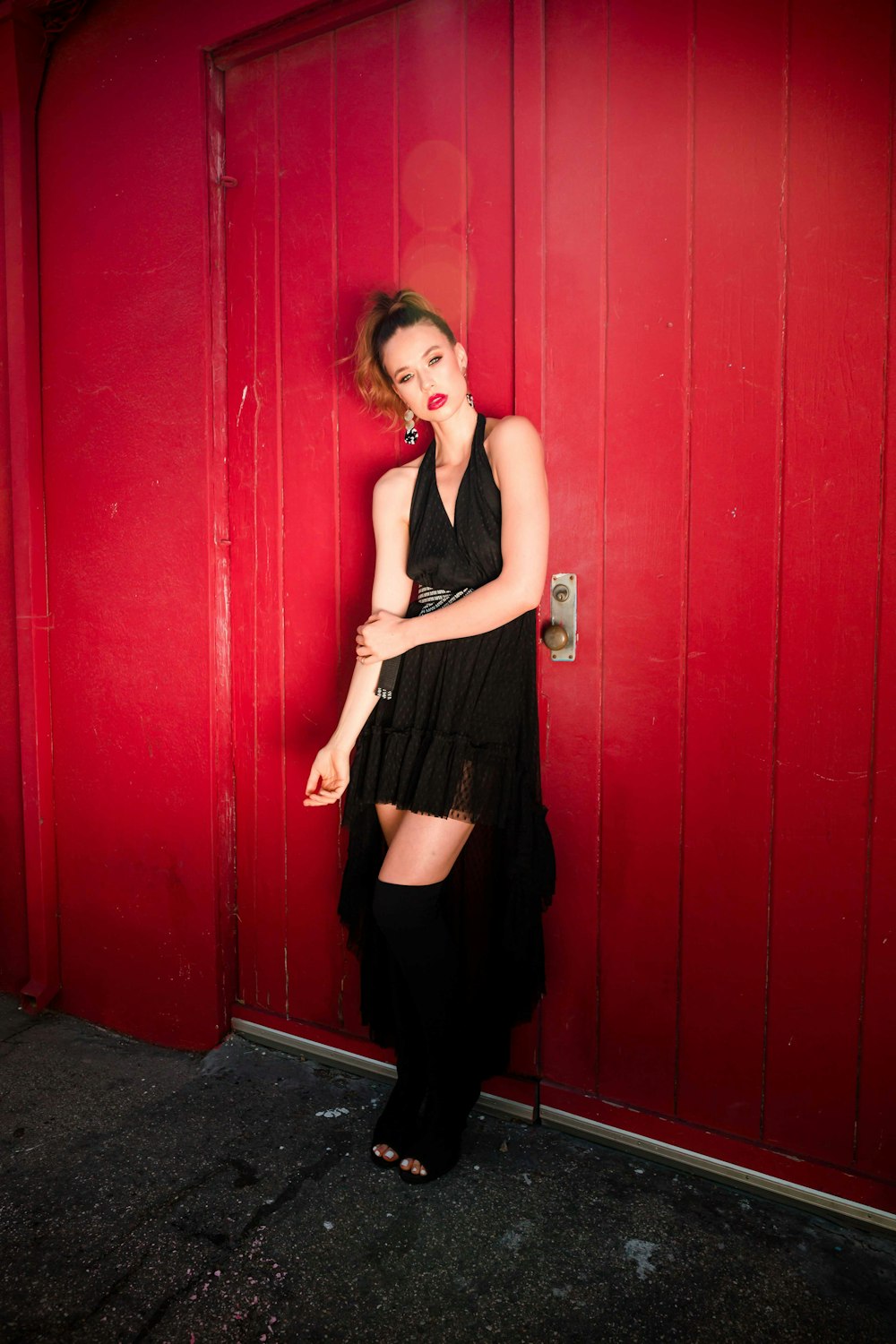 woman standing and leaning on red wall