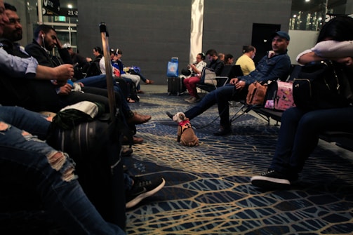 A group of happy travelers holding passports and boarding passes at an airport lounge.