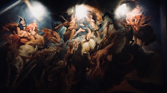 A dramatic and dynamic painting featuring a mythological scene with multiple figures and divine beings in motion. There are armored warriors, ethereal women, and horses, all enveloped in swirling clouds and light. The central figure appears to be the focus of divine attention, surrounded by celestial beings.
